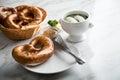 German WeiÃÅ¸wurst white sausage in porcelain pot, Bavarian sweet mustard, butter and pretzel on marble table